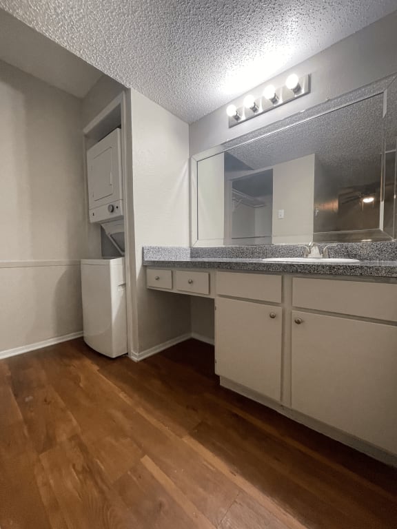 a kitchen with a sink and a mirror and a refrigerator