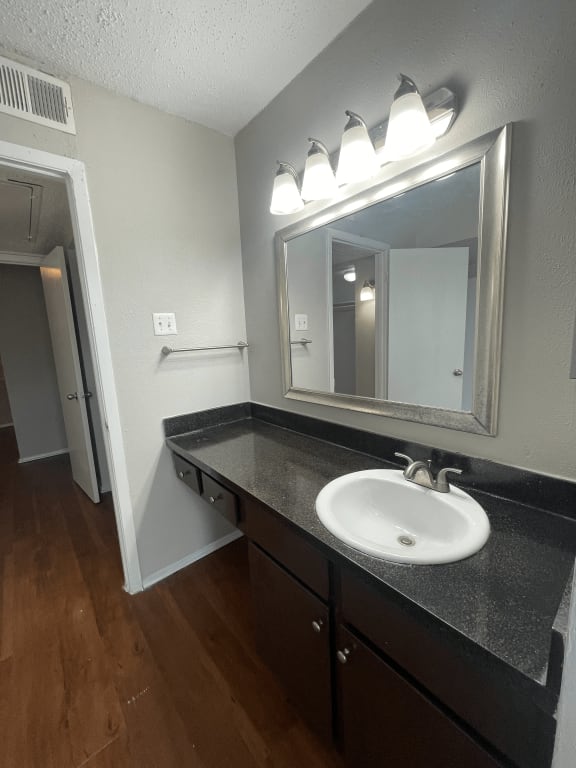 an empty bathroom with a sink and a mirror