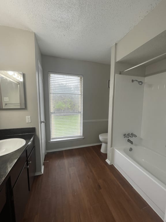an empty bathroom with a white tub and a sink and a toilet
