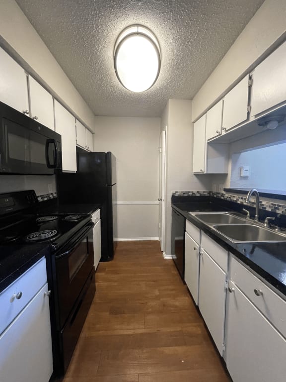 a kitchen with black appliances and white cabinets