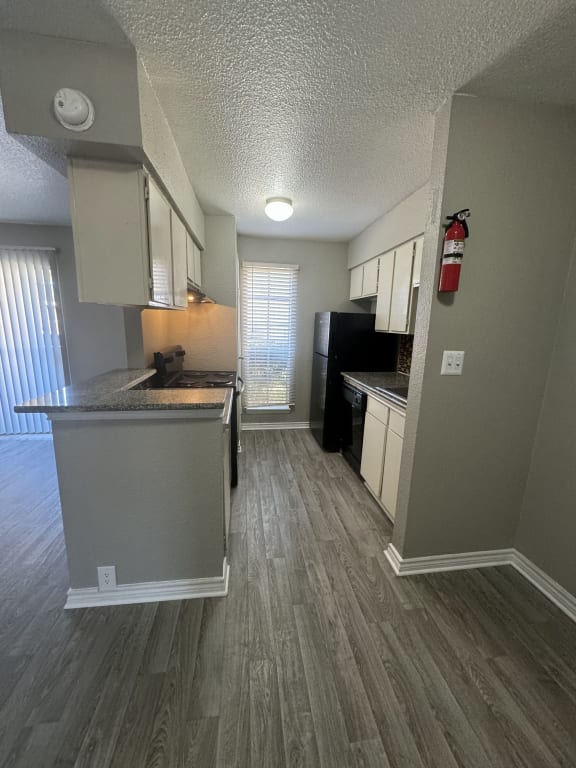 a kitchen with an island and a black refrigerator