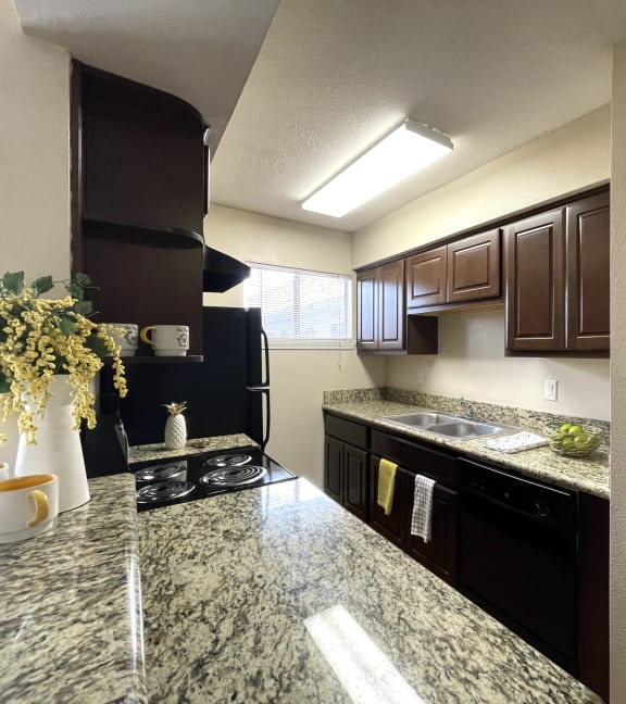 a kitchen with black appliances and granite counter tops