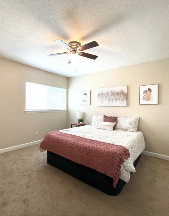 a bedroom with a bed and a ceiling fan