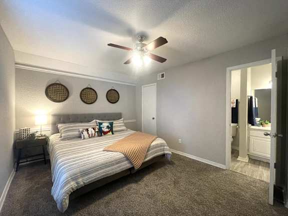 a bedroom with a large bed and a ceiling fan