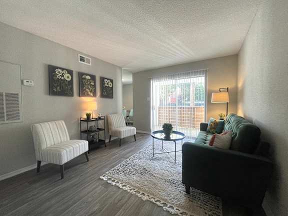 a living room with a couch and two chairs and a table