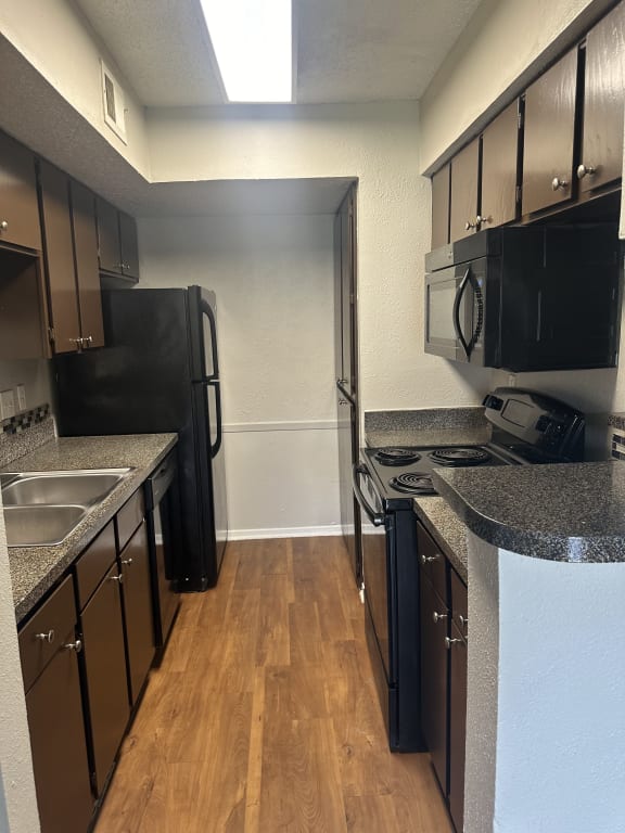 a kitchen with granite counter tops and black appliances