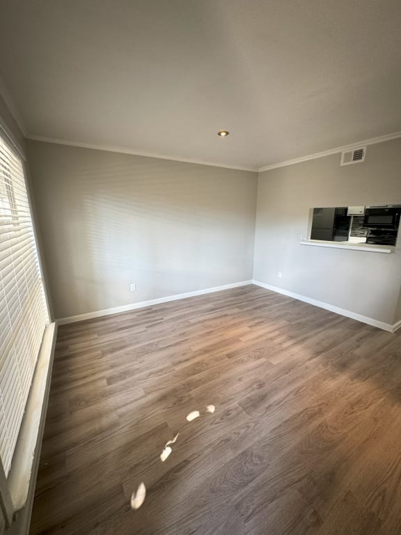 a living room with hardwood floors and a window