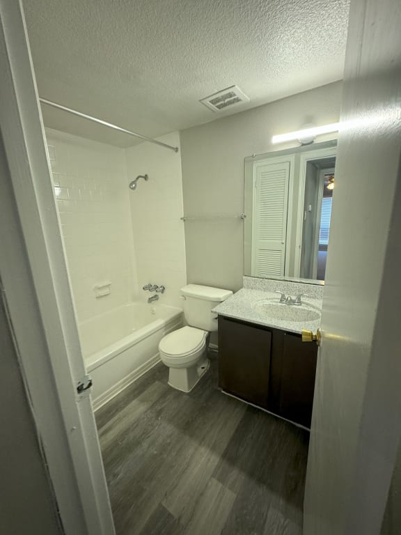 a bathroom with a toilet and a sink and a bath tub