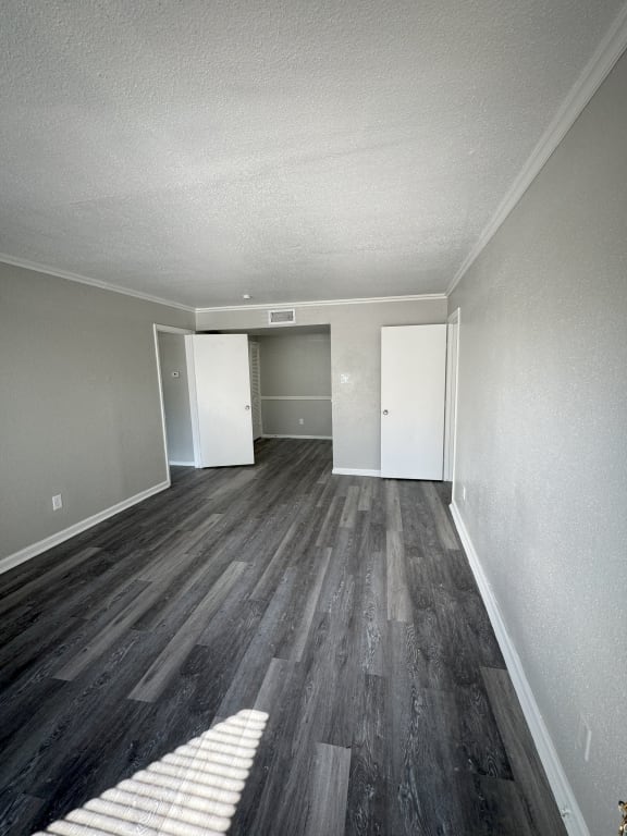 an empty living room with wood flooring and white walls