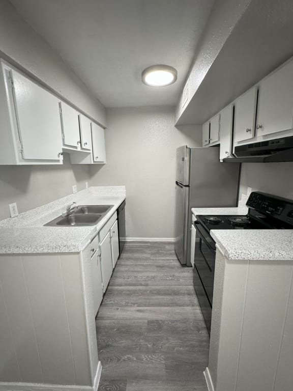 a kitchen with white cabinets and a sink and a refrigerator
