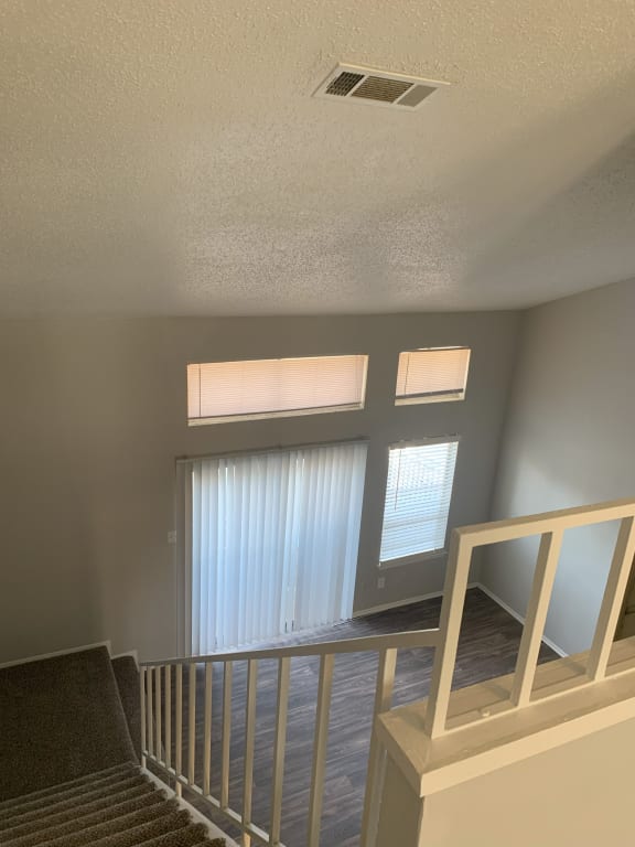 the view from the top of the stairs looking into the living room and the windows  at 1505 Exchange Apartments, Texas, 76112