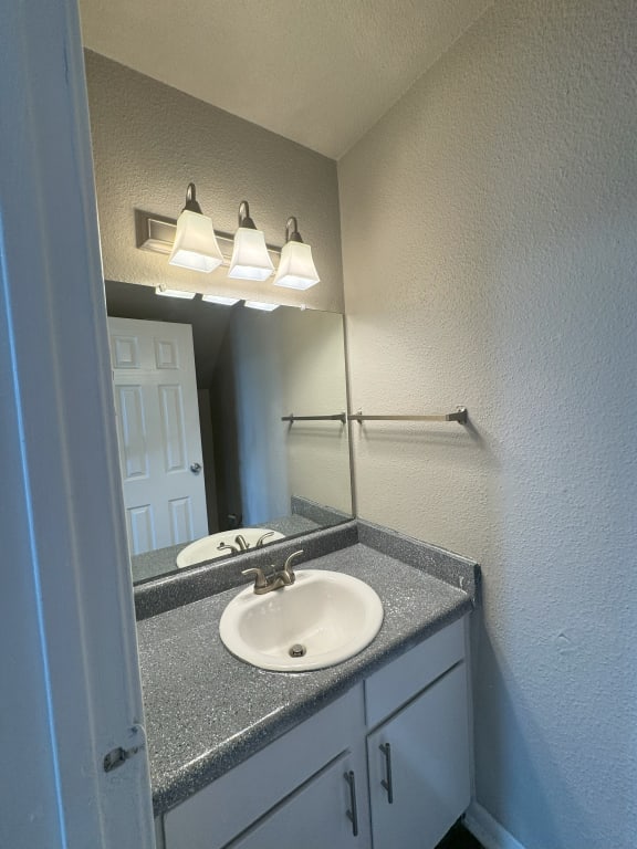 an empty bathroom with a sink and a mirror