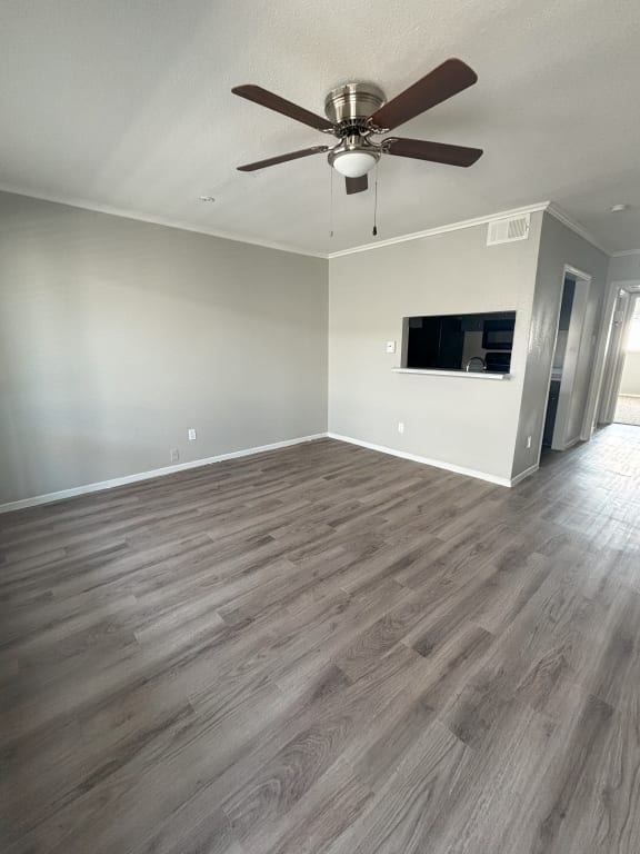 the living room of a new home with wood flooring and a ceiling fan