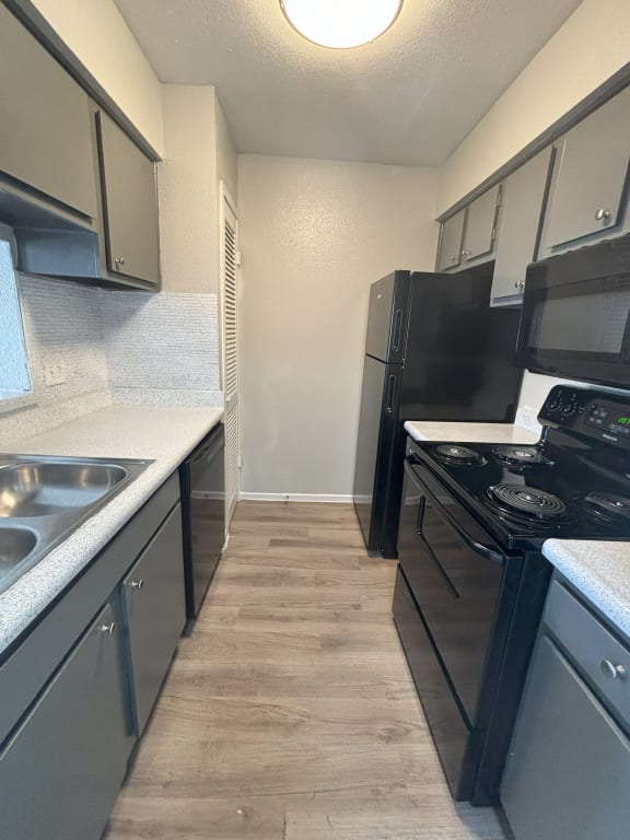 a kitchen with black appliances and white counter tops
