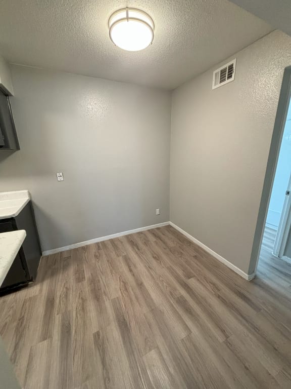 an empty living room with wood flooring and a window