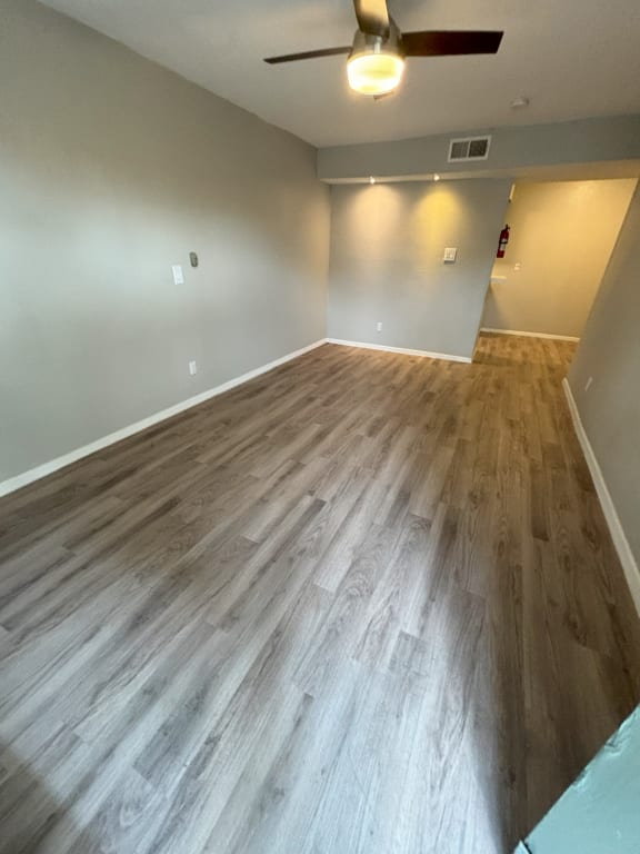 the living room has a hardwood floor and a ceiling fan