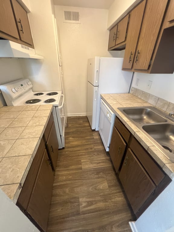 an empty kitchen with a sink and a refrigerator