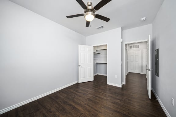 an empty room with white walls and a ceiling fan