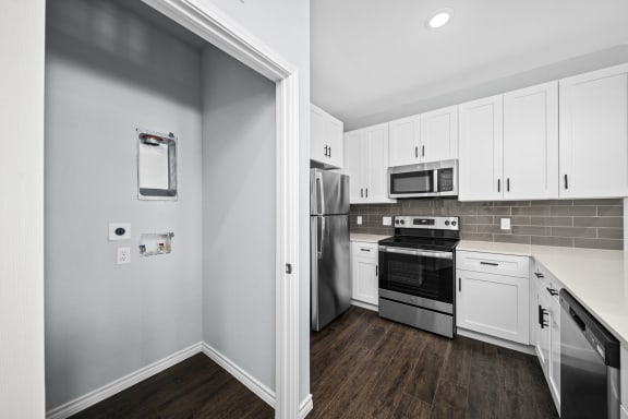 a kitchen with white cabinets and stainless steel appliances
