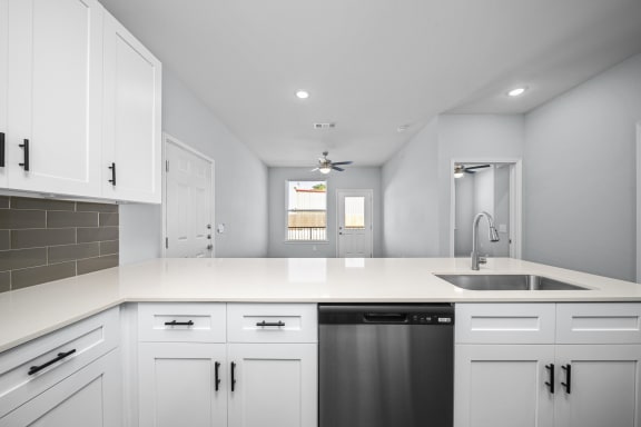 a kitchen with white cabinets and a sink and a window
