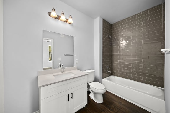 Bathroom with white vanity and gray subway tile at The Aurea Apartments, Houston, TX