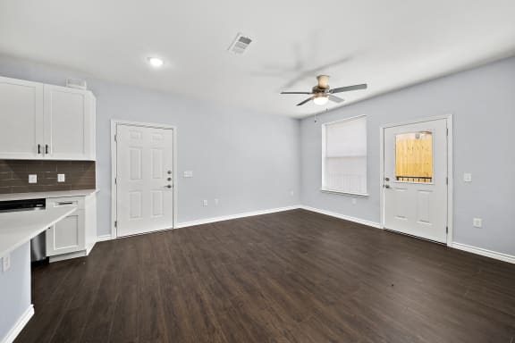 Open living space with kitchen and dark flooring at The Aurea Apartments, Texas