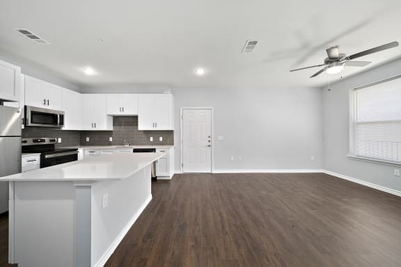Open concept kitchen and living room with hardwood floors at The Aurea Apartments, Houston, TX