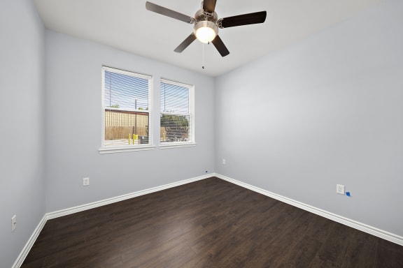 Empty bedroom with ceiling fan and windows at The Aurea Apartments, Houston, Texas
