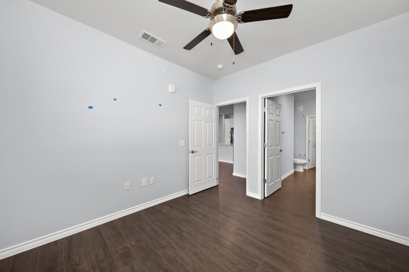 Empty room with ceiling fan and multiple doors at The Aurea Apartments, Houston, TX 77093