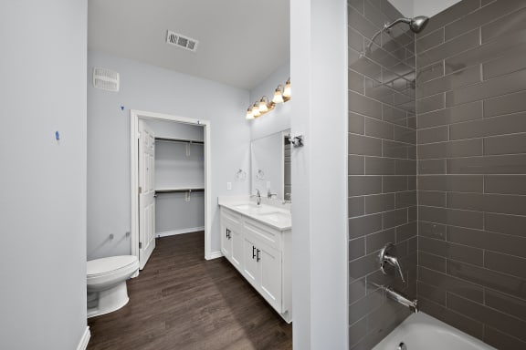 Modern bathroom with walk-in shower and double vanity at The Aurea Apartments, Houston, TX