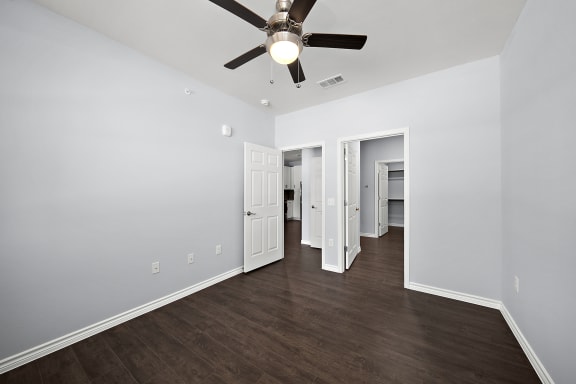 a living room with white walls and a ceiling fan