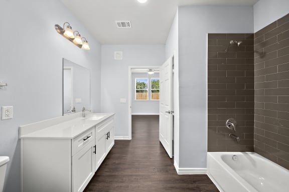 a white bathroom with a tub and a sink and a shower