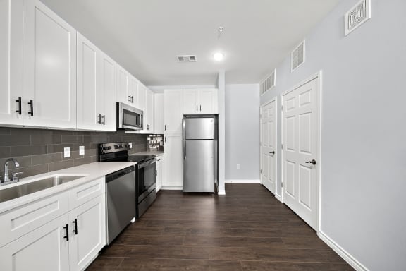 a kitchen with white cabinets and stainless steel appliances