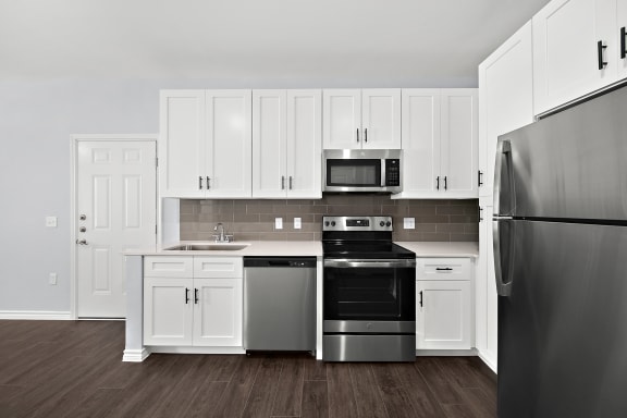 a kitchen with white cabinets and stainless steel appliances