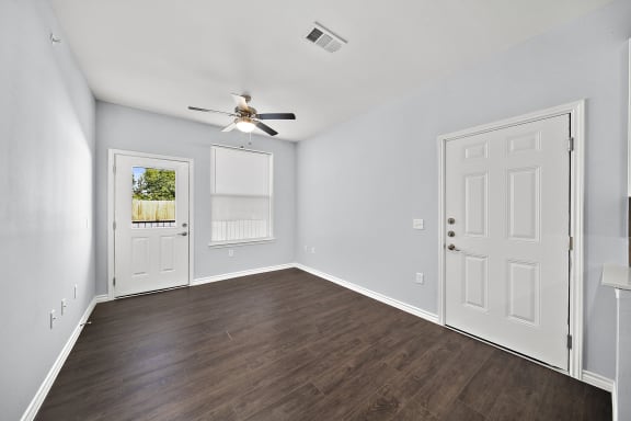 an empty room with white walls and a ceiling fan