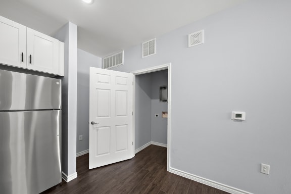 an empty room with a refrigerator and a door