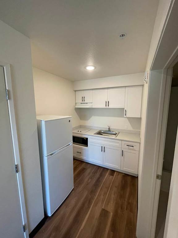 A kitchen with white appliances and cabinets.