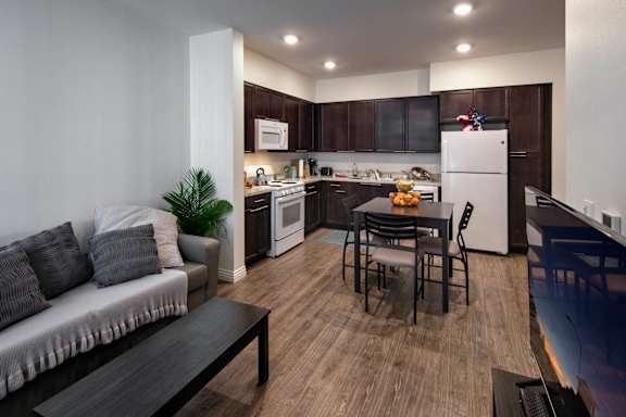 A modern kitchen with dark wood cabinets and a white refrigerator.