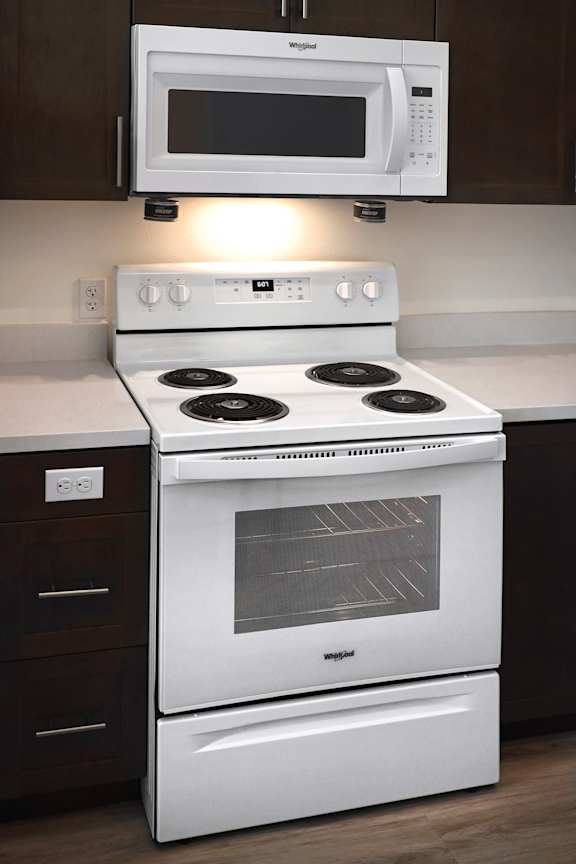 A white stove and microwave in a kitchen.