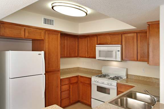 A kitchen with wooden cabinets and white appliances.