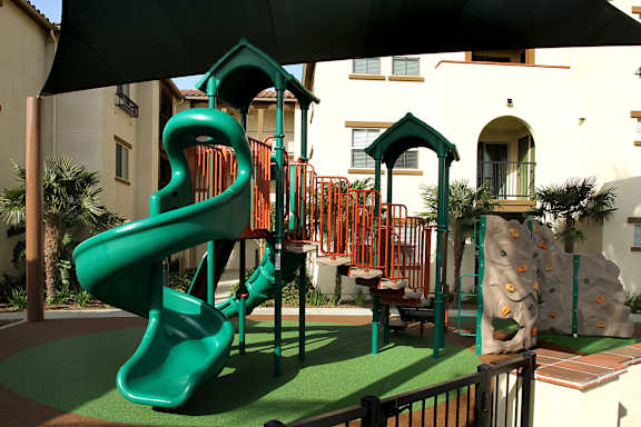 A green slide in a playground.