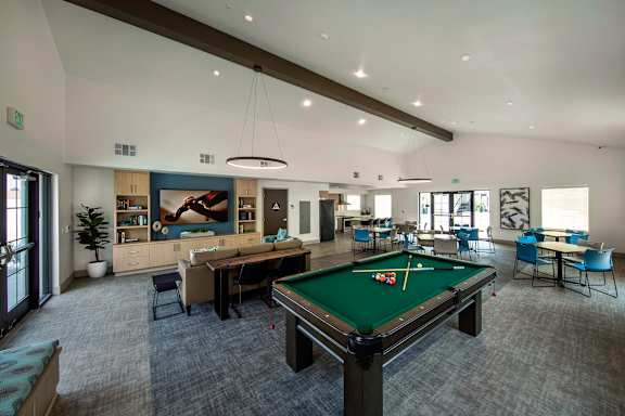 A room with a pool table and a green pool table cloth.