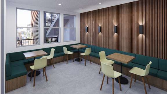 A room with a wooden wall and chairs around a table.