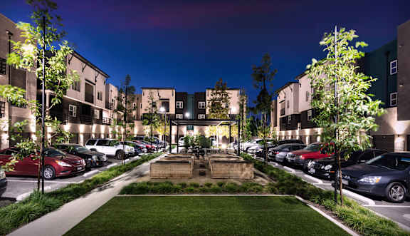 A parking lot with cars and a building in the background.