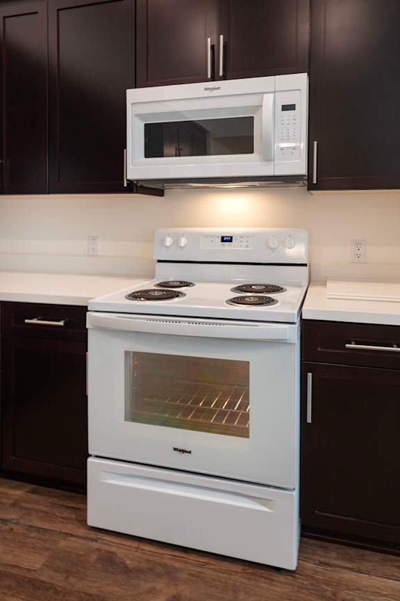 A white stove and microwave in a kitchen.