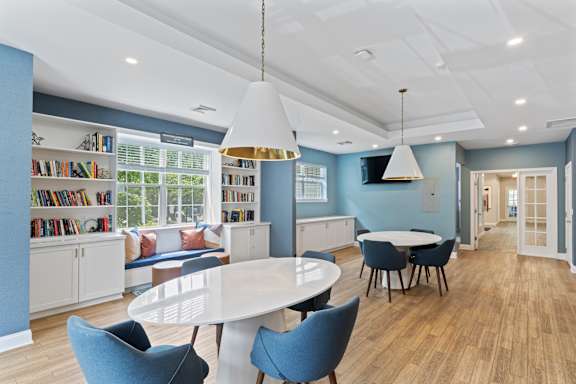 A modern dining room with a white table and blue chairs at Town Walk at Hamden Hills, Connecticut, 06518