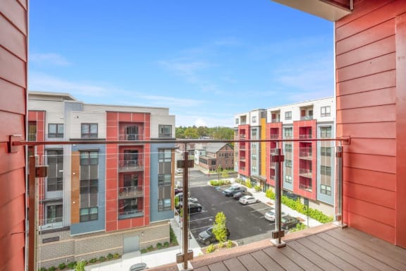 a balcony with a view of a street and some apartment buildings