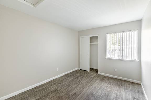 a bedroom with hardwood floors and grey walls