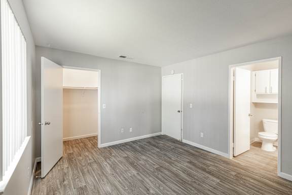 a bedroom with hardwood floors and grey walls