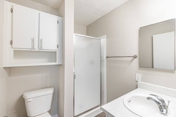 a bathroom with a toilet sink and shower